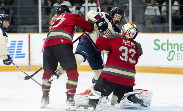 Ottawa Charge goaltender Gwyneth Philips (33) pushes Montreal Victoire's Lina Ljungblom, center, out of her crease following a stoppage in play during second-period PWHL hockey playoff action in Ottawa, Ontario, Friday, May 16, 2025. (Spencer Colby/The Canadian Press via AP)