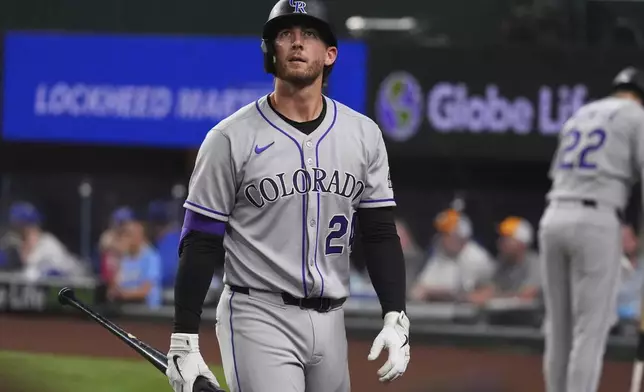 Colorado Rockies' Ryan McMahon walks to the dugout after striking out during the ninth inning of a baseball game against the Texas Rangers, Wednesday, May 14, 2025, in Arlington, Texas. (AP Photo/LM Otero)