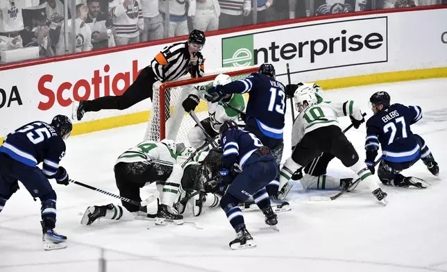 Winnipeg Jets players crowd the net around Dallas Stars goaltender Jake Oettinger trying to score in the last minutes of the third period NHL playoff hockey action in Winnipeg, Canada, Wednesday, May 7, 2025. (Fred Greenslade/The Canadian Press via AP)