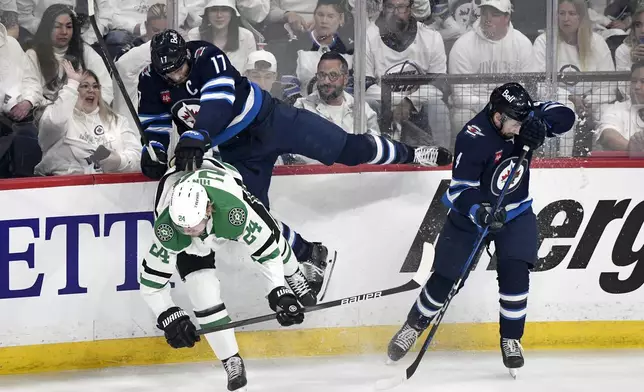 Winnipeg Jets' Adam Lowry (17) and Neal Pionk (4) collide with Dallas Stars' Roope Hintz (24) during first period NHL playoff hockey action in Winnipeg, Wednesday, May 7, 2025. (Fred Greenslade/The Canadian Press via AP)