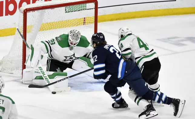 Dallas Stars goaltender Jake Oettinger (29) makes a save on Winnipeg Jets' Mason Appleton (22) during the third period of an NHL hockey playoff series in Winnipeg, Manitoba, Wednesday, May 7, 2025. (Fred Greenslade/The Canadian Press via AP)