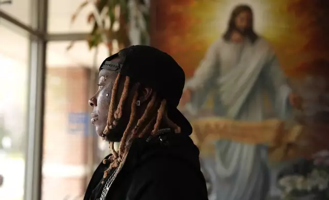 Tazz Webster, who ultimately wound up homeless after an apartment manager allegedly ridiculed and shoved him because he is transgender, exits through the front door of a community center, April 9, 2025, in St. Louis. (AP Photo/Jeff Roberson)