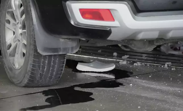 A shoe is left under a vehicle after it drove near the departure entrance at Manila's International Airport Terminal 1, killing some people while injuring others in Manila, Philippines on Sunday, May 4, 2025. (AP Photo/Aaron Favila)