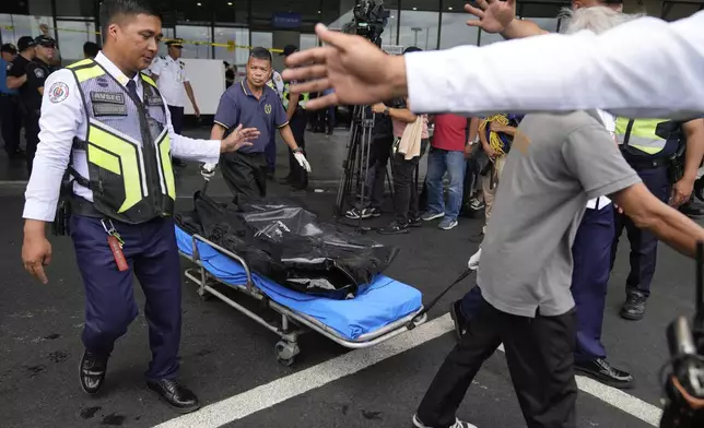 First responders bring the body of a victim after a vehicle drove near the departure entrance at Manila's International Airport Terminal 1, killing some people while injuring others in Manila, Philippines on Sunday, May 4, 2025. (AP Photo/Aaron Favila)