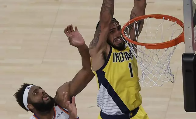 Indiana Pacers forward Obi Toppin (1) dunks the ball against New York Knicks center Mitchell Robinson (23) in overtime of Game 1 of the NBA basketball Eastern Conference final, Wednesday, May 21, 2025, in New York. (AP Photo/Adam Hunger)