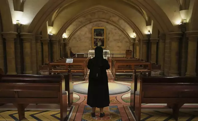 A nun pauses as she stands in front of an altar in the crypt at Saint Mary's Cathedral in Sydney, Australia, Friday, May 9, 2025. (AP Photo/Mark Baker)