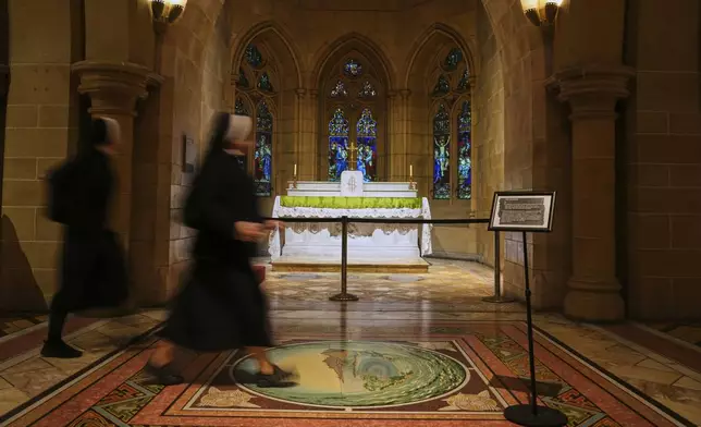 Nuns walk past an altqr at Saint Mary's Cathedral in Sydney, Australia, Friday, May 9, 2025. (AP Photo/Mark Baker)