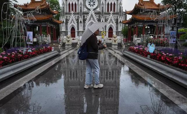 A woman visits to the Xishiku Catholic Church during a rainy day, in Beijing, Friday, May 9, 2025. (AP Photo/Andy Wong)