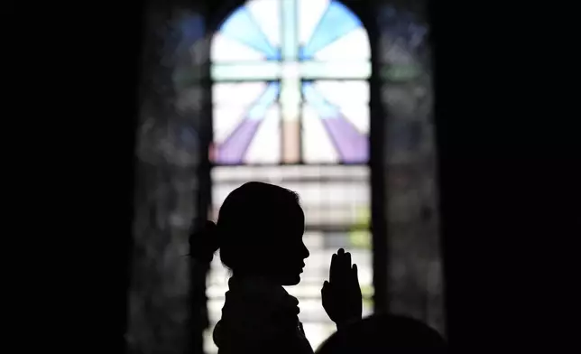 Alexandra Ivory Bonilla prays at the Imus Cathedral in Imus, Cavite province, Philippines on Friday, May 9, 2025. (AP Photo/Aaron Favila)
