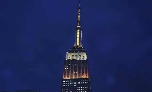 The Empire State Building is lit in gold and white in honor of Pope Leo XIV Thursday, May 8, 2025, in New York. (AP Photo/Frank Franklin II)