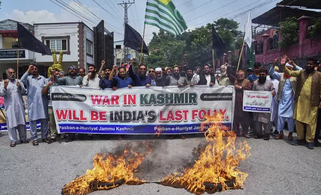Supporters of Pasban-e-Hurriyat Jammu and Kashmir chant slogans next to burning tires during an anti-India demonstration, in Muzaffarabad, the capital of Pakistan administered Kashmir, Monday, May 5, 2025. (AP Photo/M.D. Mughal)