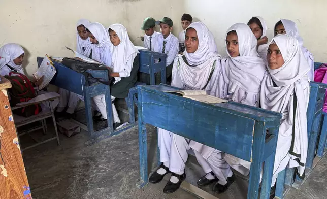 Students attend their class in Aligarh School and College of Commerce and Science in Dara Batang during a government's organized trip for media to Bella Noor Shah, a mountainous village near Muzaffarabad, the capital of Pakistan administered Kashmir, Monday, May 5, 2025. (AP Photo/Muhammad Yousuf, Pool)