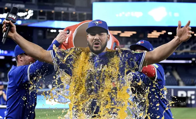 Toronto Blue Jays' Anthony Santander is doused by teammates after the Blue Jays defeated the San Diego Padres in MLB baseball action in Toronto on Tuesday, May 20, 2025. (Jon Blacker/The Canadian Press via AP)