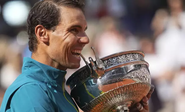 FILE - Spain's Rafael Nadal bites the trophy after winning the final match against Norway's Casper Ruud in three sets, 6-3, 6-3, 6-0, at the French Open tennis tournament in Roland Garros stadium in Paris, France, June 5, 2022. (AP Photo/Michel Euler, File)