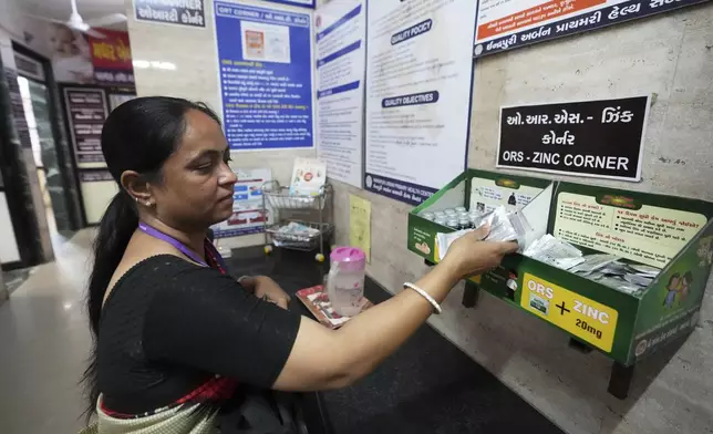 Asha worker Shashi Mishra collects oral rehydration solution pouches before leaving for her job from an urban health center in Ahmedabad, India, Wednesday, April 2, 2025. (AP Photo/Ajit Solanki)