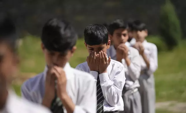 Kashmiri school children pray during the morning assembly after schools reopened, following a ceasefire agreement between India and Pakistan on Saturday, in Srinagar, Indian controlled Kashmir, Tuesday, May 13, 2025. (AP Photo/Mukhtar Khan)