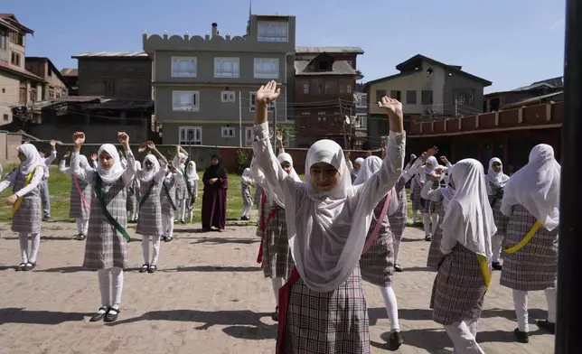 Kashmiri school children attend the morning assembly after schools reopened, following a ceasefire agreement between India and Pakistan on Saturday, in Srinagar, Indian controlled Kashmir, Tuesday, May 13, 2025. (AP Photo/Mukhtar Khan)