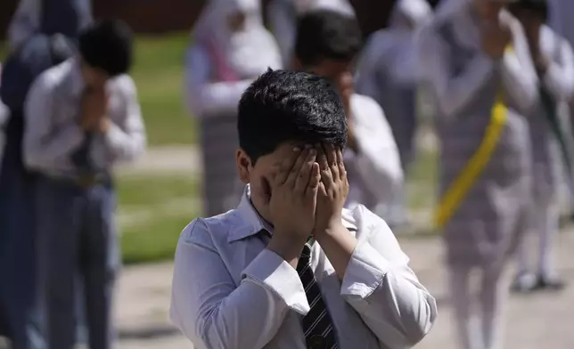 Kashmiri school children pray during the morning assembly after schools reopened, following a ceasefire agreement between India and Pakistan on Saturday, in Srinagar, Indian controlled Kashmir, Tuesday, May 13, 2025. (AP Photo/Mukhtar Khan)