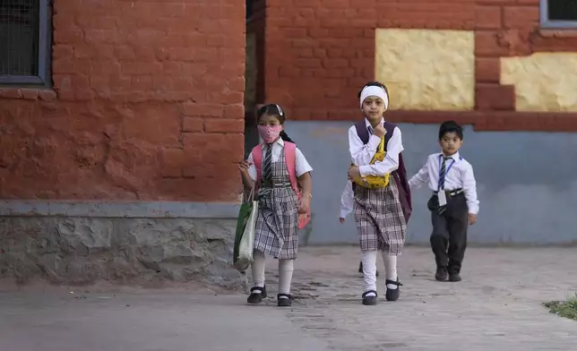 Kashmiri school children arrive at school after schools reopened, following a ceasefire agreement between India and Pakistan on Saturday, in Srinagar, Indian controlled Kashmir, Tuesday, May 13, 2025. (AP Photo/Mukhtar Khan)