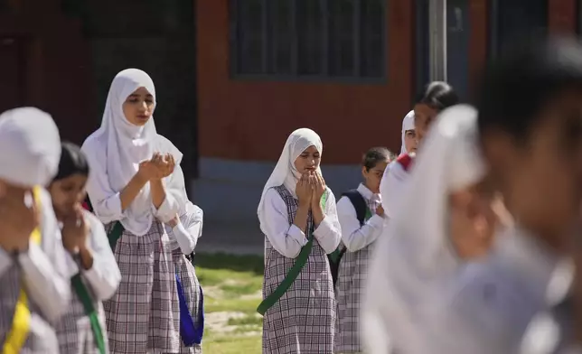 Kashmiri school children pray during the morning assembly after schools reopened, following a ceasefire agreement between India and Pakistan on Saturday, in Srinagar, Indian controlled Kashmir, Tuesday, May 13, 2025. (AP Photo/Mukhtar Khan)