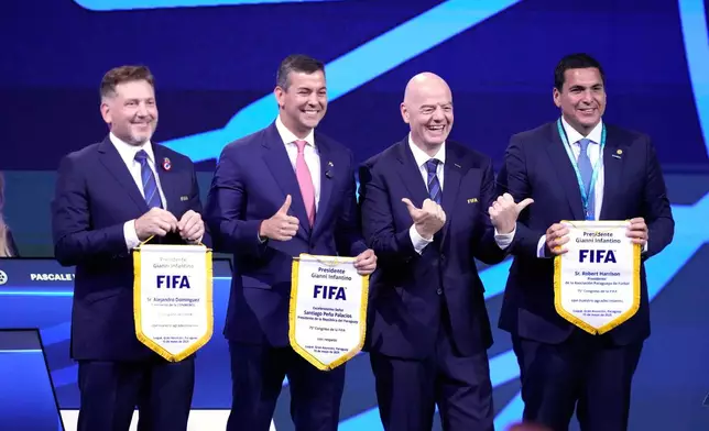 From left, Conmebol's President Alejandro Dominguez, Paraguay's President Santiago Pena, FIFA's President Gianni Infantino, and Paraguay's Soccer Association's President Robert Harrison stand before attendees of the FIFA 75th Congress at the Conmebol Convention Center in Luque, Paraguay, Thursday, May 15, 2025. (AP Photo/Fernando Calistro)