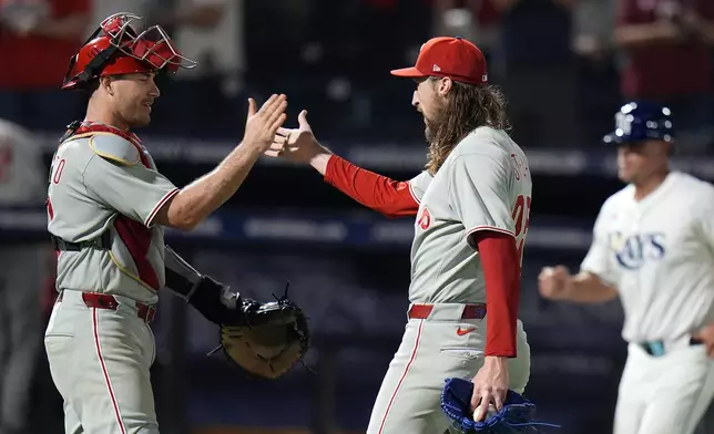 Philadelphia Phillies catcher J.T. Realmuto, left, celebrates with pitcher Matt Strahm after closing out the Tampa Bay Rays during the 10th inning of a baseball game Thursday, May 8, 2025, in Tampa, Fla. (AP Photo/Chris O'Meara)