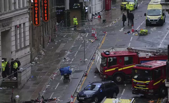 Fans leave as Police and emergency personnel deal with an incident after a car collided with pedestrians near the Liver Building during the Premier League winners parade in Liverpool, England, Monday, May 26, 2025.(AP Photo/Jon Super)