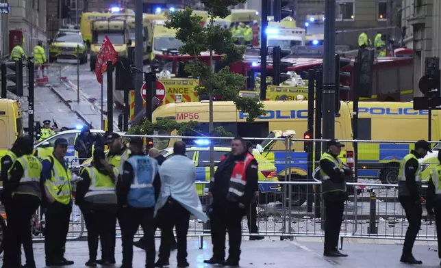 Police and emergency personnel deal with an incident near the Liver Building during the Premier League winners parade in Liverpool, England, Monday, May 26, 2025.(AP Photo/Jon Super)