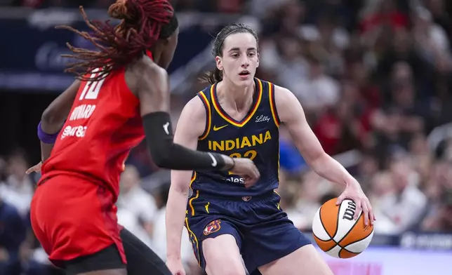 Indiana Fever guard Caitlin Clark (22) drives on Atlanta Dream guard Rhyne Howard (10) in the first half of a WNBA basketball game in Indianapolis, Tuesday, May 20, 2025. (AP Photo/Michael Conroy)