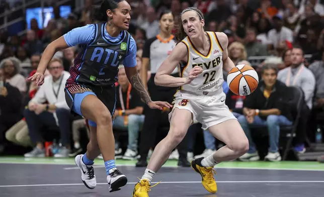 Indiana Fever guard Caitlin Clark (22) creates space against Atlanta Dream guard Te-Hina Paopao (2) in the first half of an WNBA basketball game, Thursday, May, 22, 2025, in Atlanta. (AP Photo/Colin Hubbard)