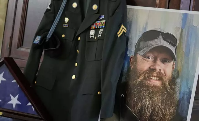 The Army dress uniform and photo of the late Christopher Pelkey is shown at his mother's home, Wednesday, May 7, 2025, in Chandler, Ariz. (AP Photo/Matt York)