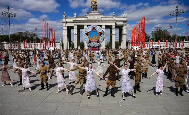 Moscow students dressed in the fashion of the middle of the last century and Soviet style uniform perform "Victory Waltz" as a part of Victory Day celebration in front of the a model of the main Soviet order, the Order of Victory at the historical gate of VDNKh, The Exhibition of Achievements of National Economy in Moscow, Russia, Tuesday, May 6, 2025. (AP Photo/Alexander Zemlianichenko)