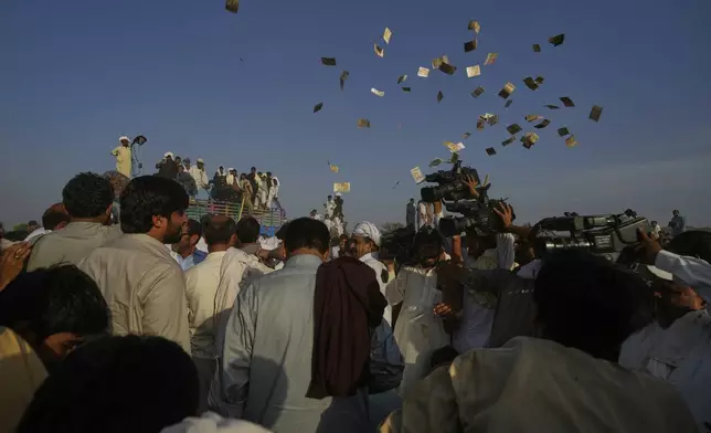 Members of a team blow currency notes in the air as they celebrating after winning a traditional bull race competition, in Malal, a village of Attock district, in Pakistan, Thursday, May 15, 2025. (AP Photo/Anjum Naveed)