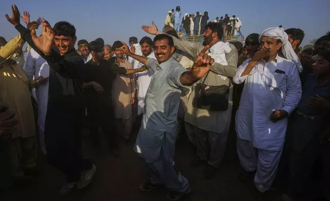 Members of a team dance as they celebrating after winning a traditional bull race competition, in Malal, a village of Attock district, in Pakistan, Thursday, May 15, 2025. (AP Photo/Anjum Naveed)