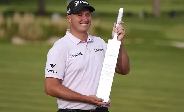 Sepp Straka, of Austria, poses with the trophy after winning the Truist Championship golf tournament at the Philadelphia Cricket Club, Sunday, May 11, 2025, in Flourtown. (AP Photo/Matt Rourke)