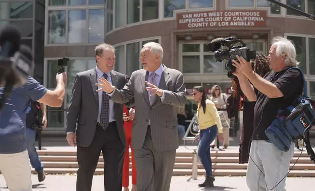 Attorney Mark Geragos, center, who represents Erik and Lyle Menendez, leaves the courthouse during break from the brothers' resentencing hearing Tuesday, May 13, 2025, in Los Angeles. (AP Photo/Damian Dovarganes)