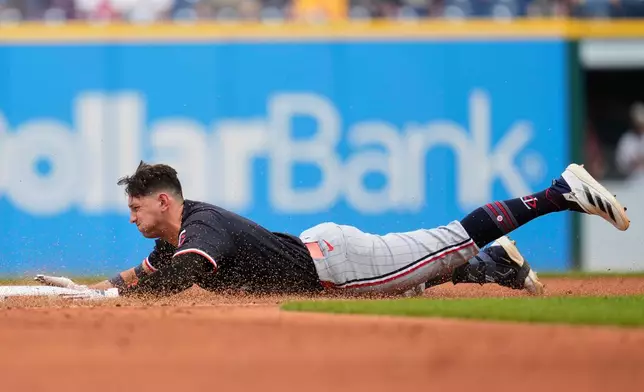 Minnesota Twins' Brooks Lee slides into second base with a double in the second inning of a baseball game against the Cleveland Guardians in Cleveland, Thursday, May 1, 2025. (AP Photo/Sue Ogrocki)