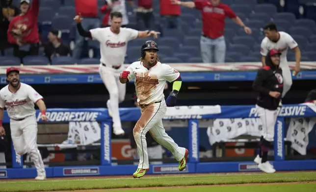 Cleveland Guardians' Jose Ramirez, center front, runs home with the winning run on a hit by Angel Martinez in the 10th inning of a baseball game against the Minnesota Twins in Cleveland, Thursday, May 1, 2025. (AP Photo/Sue Ogrocki)
