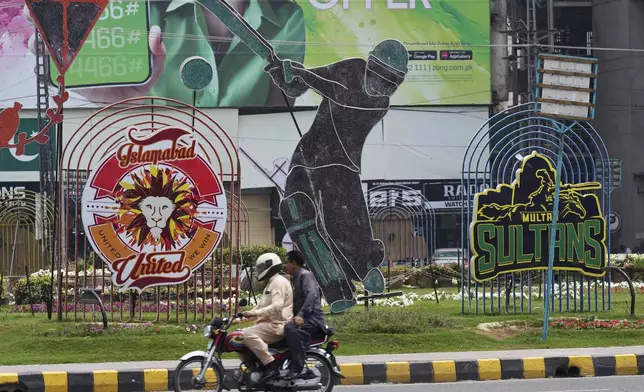 A motorcyclist drives past an advertisement of Pakistan Super League Twenty20 tournament displayed along a roadside in Lahore, Pakistan, Friday, May 9, 2025. (AP Photo/K.M. Chaudary)