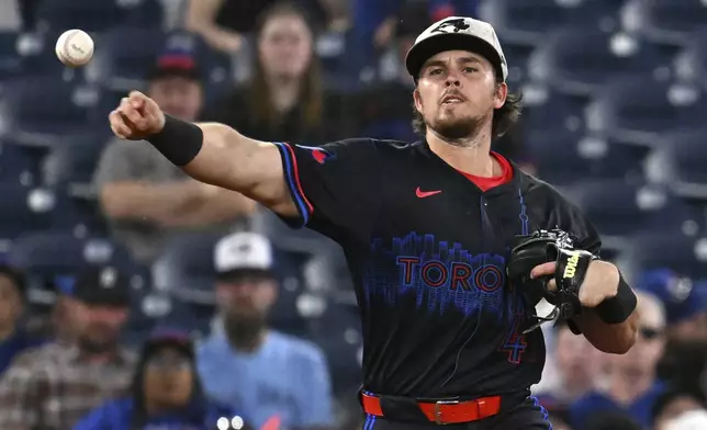 Toronto Blue Jays third baseman Addison Barger throws to first base against the Detroit Tigers in sixth-inning baseball game action in Toronto, Friday, May 16, 2025. (/Jon Blacker/The Canadian Press via AP)
