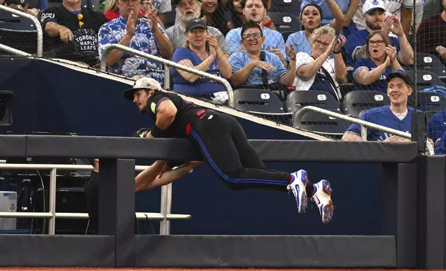 Toronto Blue Jays third baseman Addison Barger, center, catches a foul fly ball off the bat of Detroit Tigers' Trey Sweeney in fourth-inning baseball game action in Toronto, Friday, May 16, 2025. (/Jon Blacker/The Canadian Press via AP)