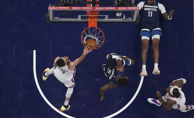 Oklahoma City Thunder forward Chet Holmgren (7) dunks next to Minnesota Timberwolves guard Anthony Edwards (5) and center Naz Reid (11) during the second half of Game 4 of the Western Conference finals of the NBA basketball playoffs, Monday, May 26, 2025, in Minneapolis. (AP Photo/Abbie Parr)