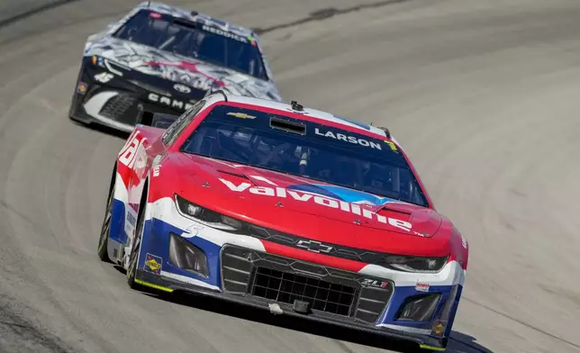 Kyle Larson, front, leads the pack with Tyler Reddick in pursuit while coming out of Turn 4 during a NASCAR Cup Series auto race at Texas Motor Speedway in Fort Worth, Texas, Sunday, May 4, 2025. (AP Photo/Larry Papke)