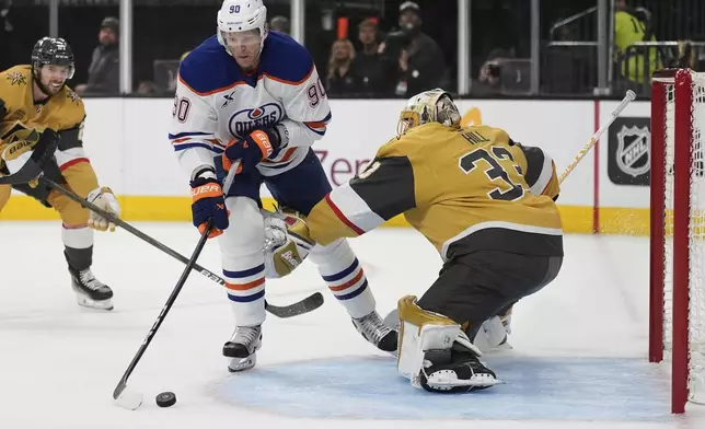 Edmonton Oilers right wing Corey Perry (90) scores against Vegas Golden Knights goaltender Adin Hill (33) during the first period of Game 1 of a second-round NHL hockey playoff series Tuesday, May 6, 2025, in Las Vegas. (AP Photo/John Locher)