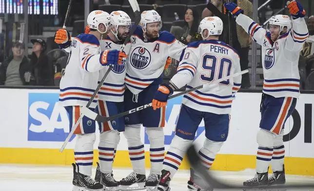 Edmonton Oilers center Leon Draisaitl (29) celebrates with teammates after scoring against the Vegas Golden Knights during the third period of Game 1 of a second-round NHL hockey playoff series Tuesday, May 6, 2025, in Las Vegas. (AP Photo/John Locher)