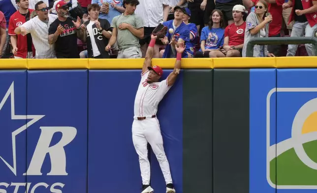 Cincinnati Reds right fielder Will Benson leaps for but misses a solo home run hit by Chicago Cubs' Reese McGuire in the second inning of a baseball game, Sunday, May 25, 2025, in Cincinnati. (AP Photo/Carolyn Kaster)