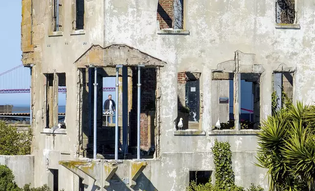 A visitor looks at the warden's house at Alcatraz Island on Monday, May 5, 2025, in San Francisco. (AP Photo/Noah Berger)