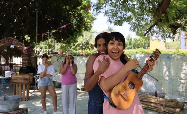 Mulato Teatro cast members Eréndira Castorela, strumming a jarana jarocha, and Marisol Castillo, rehearse for their upcoming performance in the First International Afro-Scenic Festival, in Ticumán, Mexico, Saturday, May 17, 2025. (AP Photo/Ginnette Riquelme)