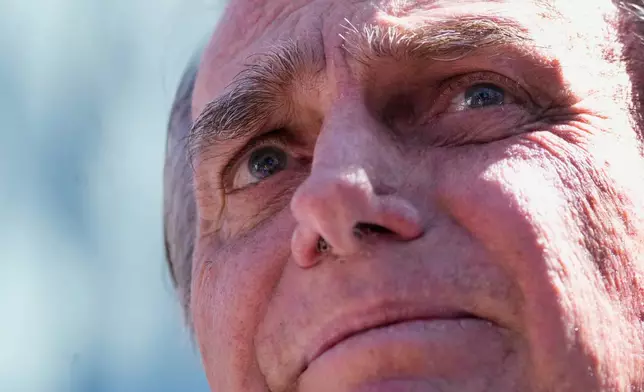 Former President Jair Bolsonaro talks to the press as he leaves the hospital after a weeks-long surgical stay, in Brasilia, Brazil, Sunday, May 4, 2025. (AP Photo/Eraldo Peres)