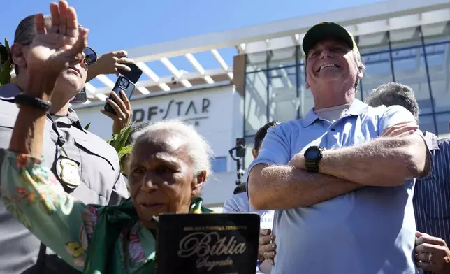 Former President Jair Bolsonaro receives a supporter's prayers as he leaves the hospital after a weeks-long surgical stay, in Brasilia, Brazil, Sunday, May 4, 2025. (AP Photo/Eraldo Peres)